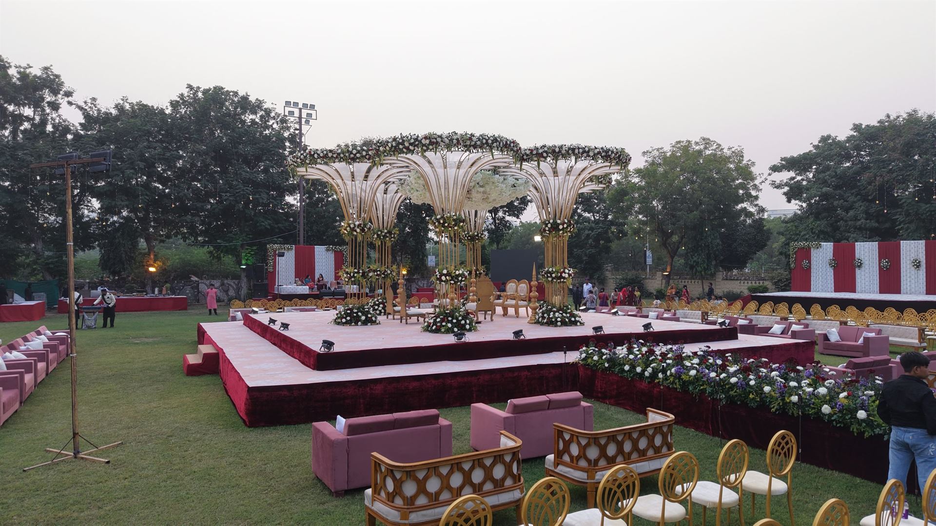 Gold fan mandap with white and burgundy floral decoration at an Ahmedabad wedding