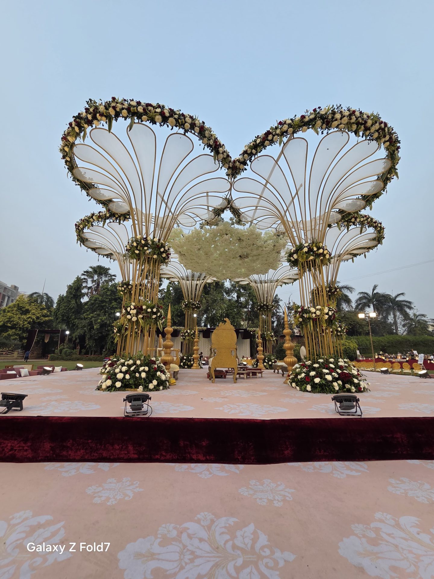 Wedding mandap with petal fan backdrop and pastel floral decoration